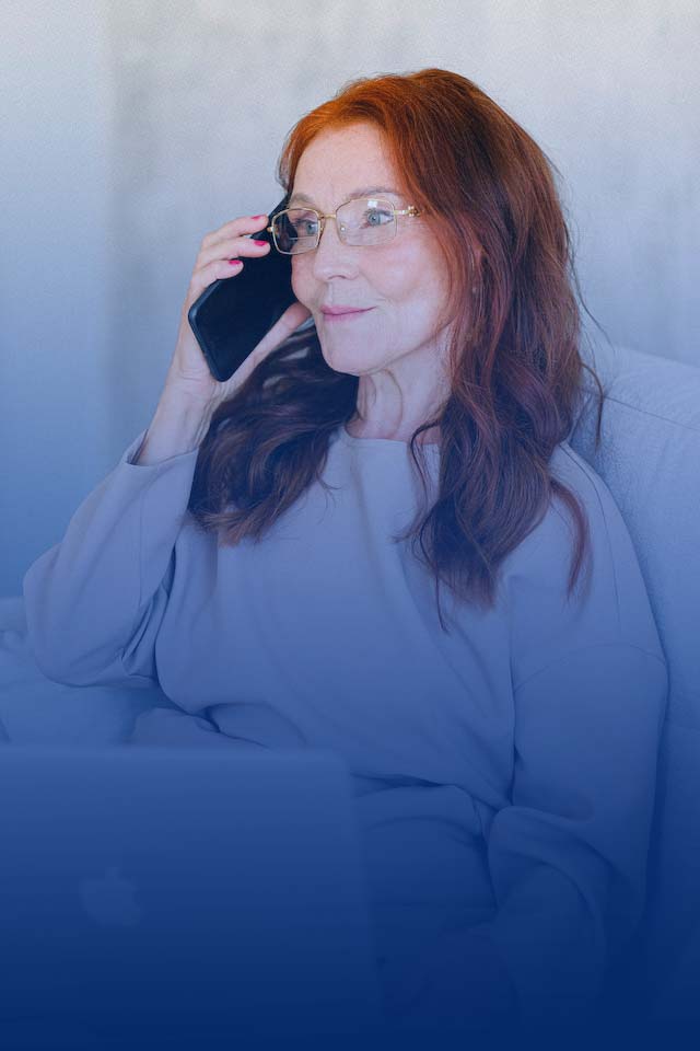 Photo by Anna Shvets: https://www.pexels.com/photo/elderly-woman-with-red-hair-talking-on-smartphone-at-laptop-5257549/